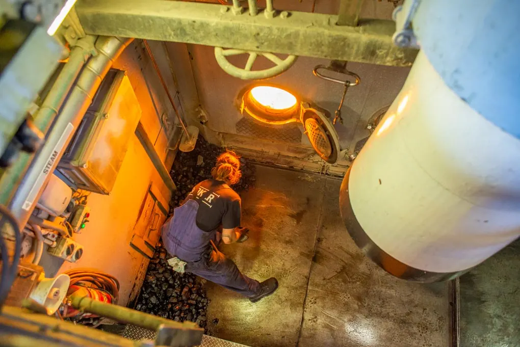 A man puts coal in the engine of the TSS Earnslaw in Queenstown