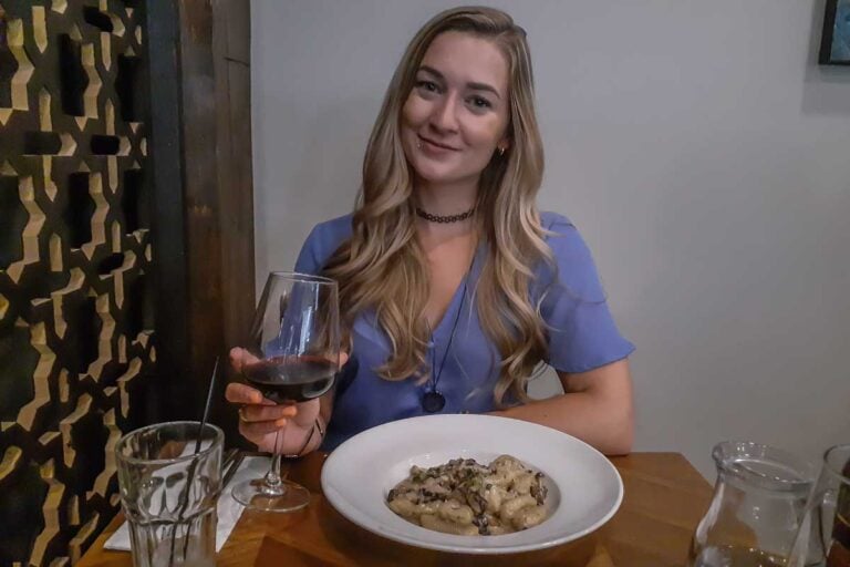 Bailey at Vaticano Cucina, Edmonton with a glass of wine and pasta