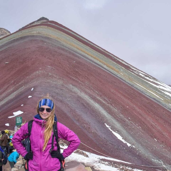 Bailey takes a photo with Rainbow Mountain in the background