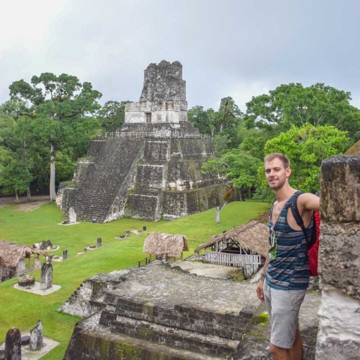 Daniel stands on a temple in Tikal and looks down at the restored ruins