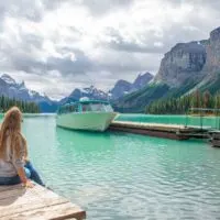 Bailey sits on the dock looking out over Maligne Lake on the tour to Spirit Island, Jasper National Park