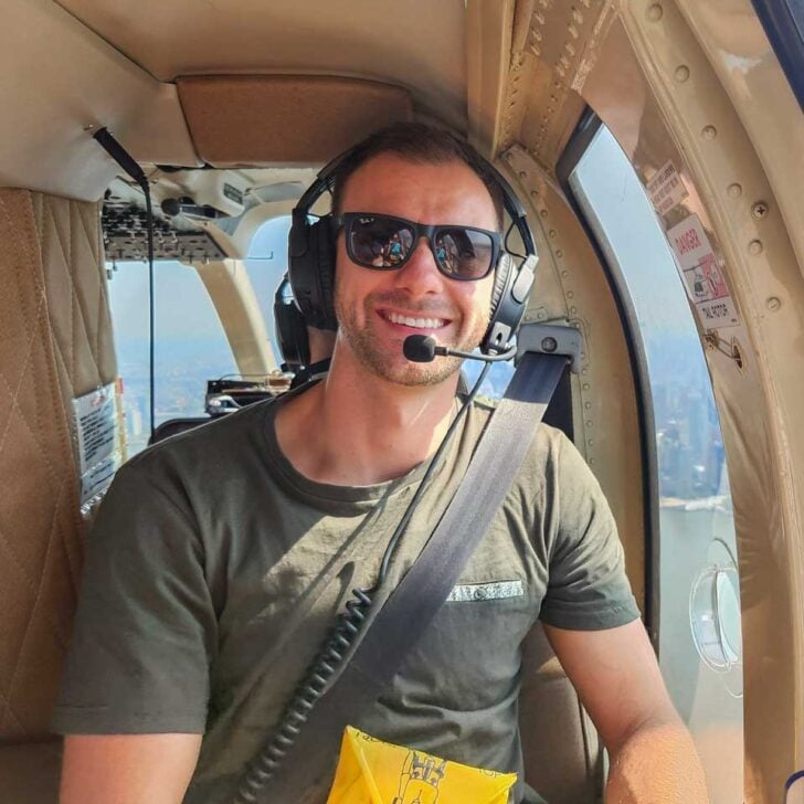Daniel smiles at the camera while sitting in a helicopter in Vancouver