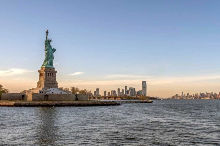The Statue of Liberty seen at sunrise from the water in New York United States