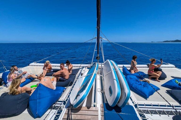 Stand up paddle boards on the deck of the sabre catamaran with other people talking and taking photos Fiji