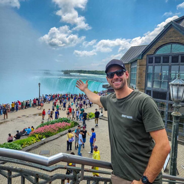 Daniel smiling and gesturing to Niagara Falls canada