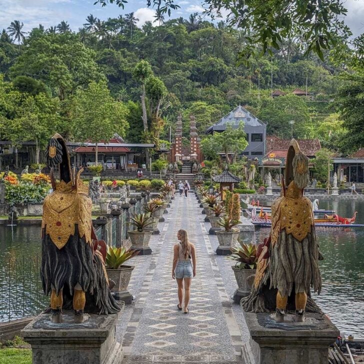 Bailey walks across a bridge at tirta gangga on the instagram tour bali