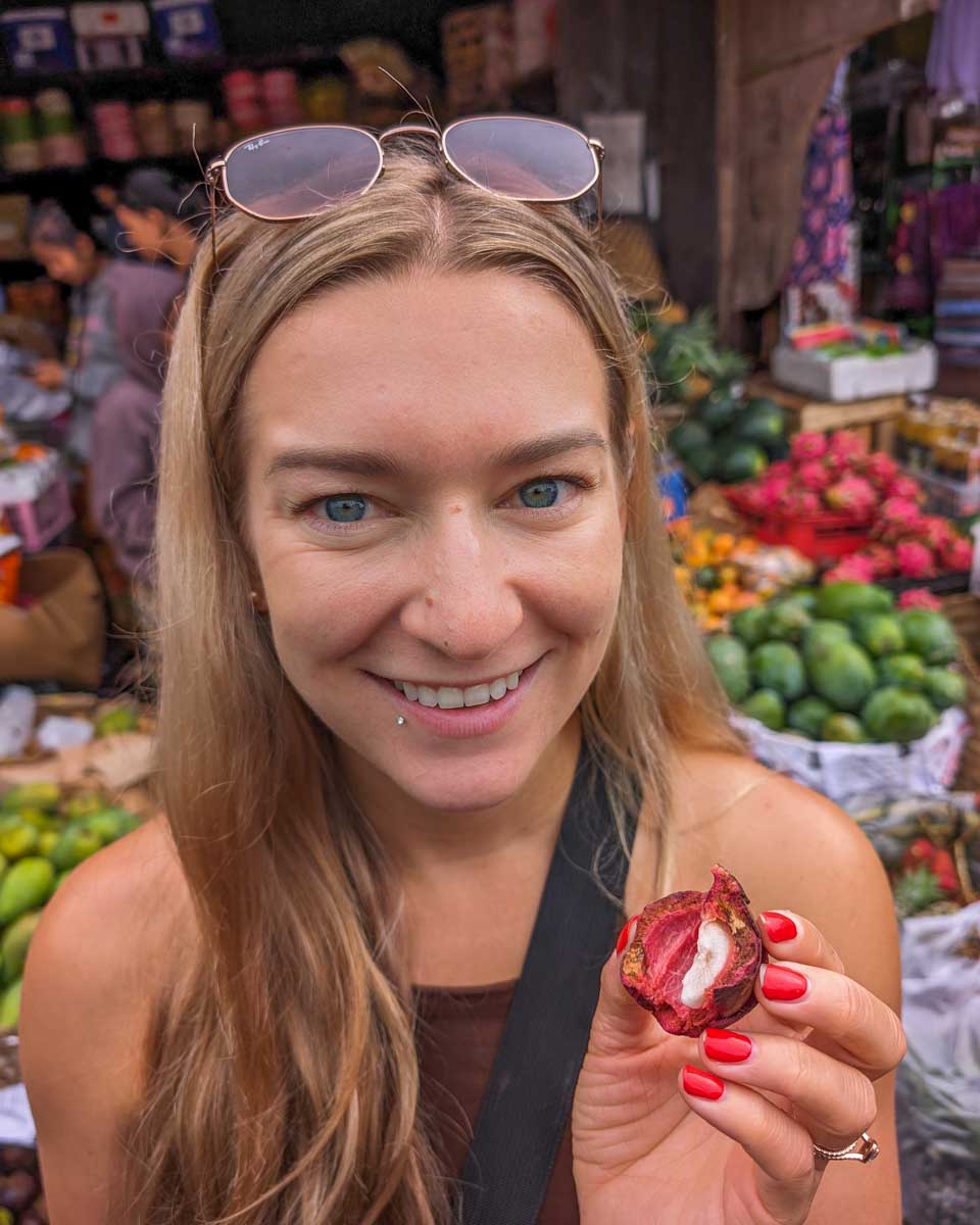 Bailey-trys-some-fruit-during-a-market-tour-on-a-cooking-class-in-Panama City Panama