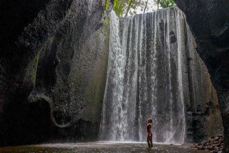 Bailey stands at Tukad Cepung in Bali on a waterfall tour