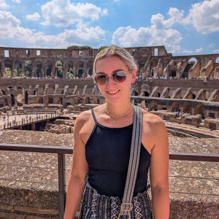 Bailey smiles and sttands in the colosseum in Rome Italy