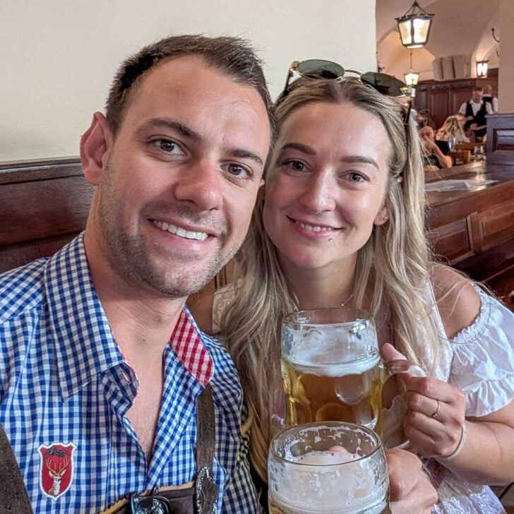 Daniel and Bailey smile and drink beer in a bar in Munich Germany