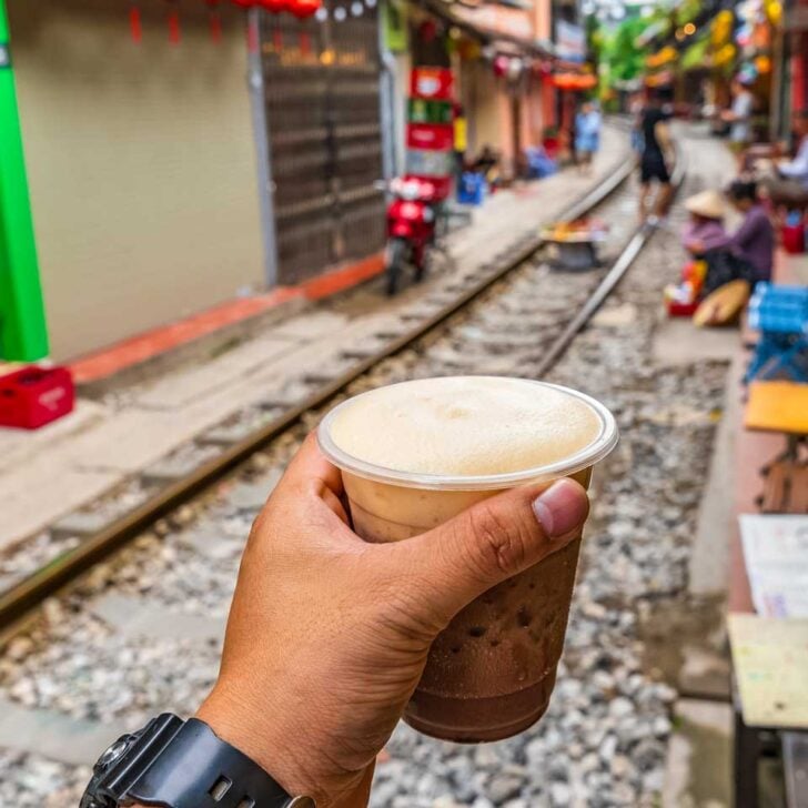 A person drinks coffee on train street in Hanoi Vietnam