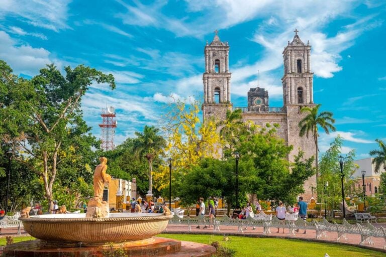 A shot of Merida with people walking and a cathedral in the back Merida Mexico