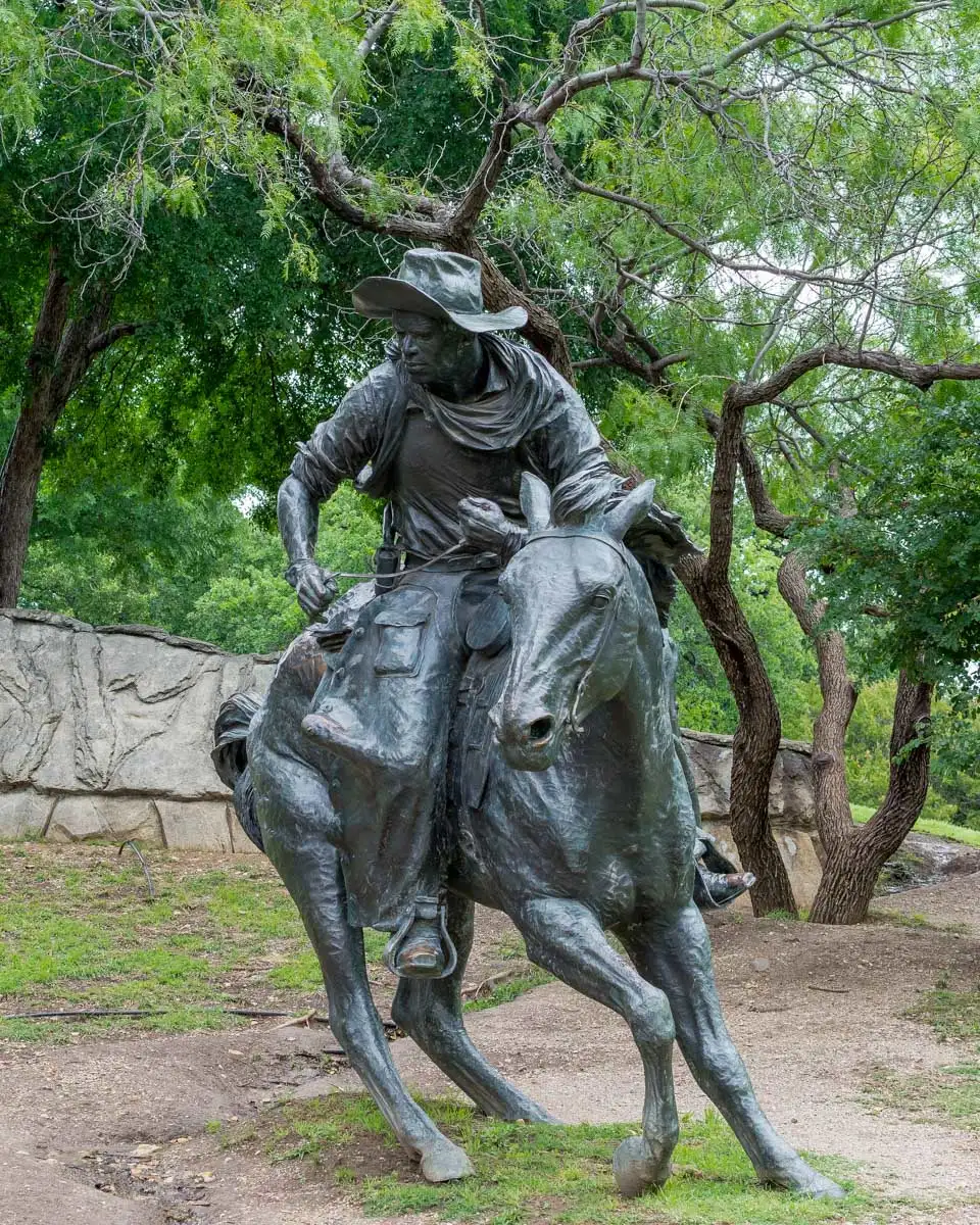 A broze sculpture of a cowboy in pioneer plaza Dallas Texas