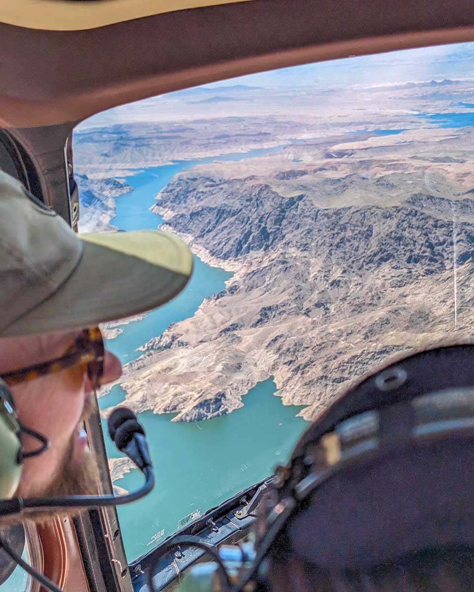 A-person-looks-out-the-window-of-a-helicopter-on-a-tour-to-the-grand-canyon-from-Phoenix Arizona