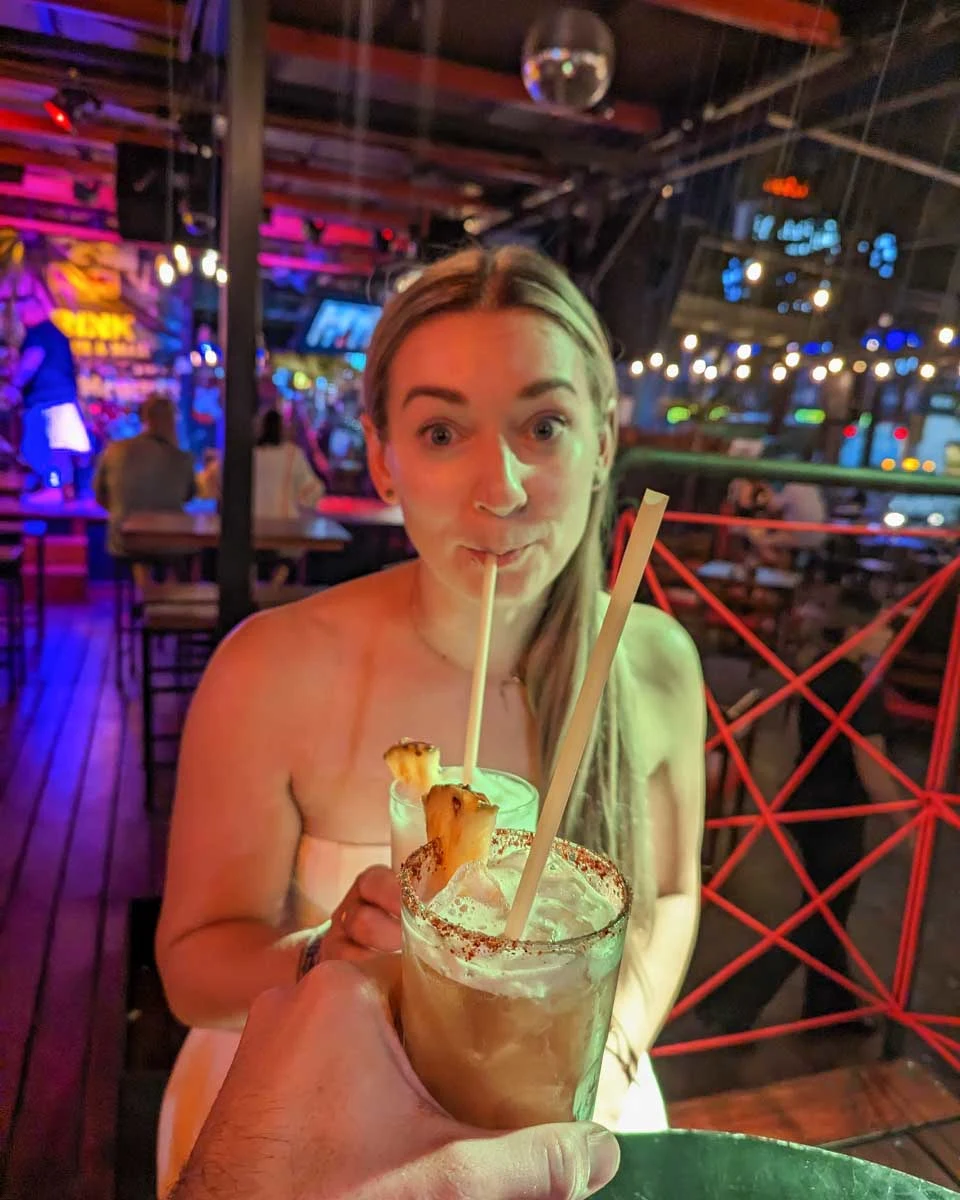 Bailey drinks a cocktail on a party bike pub crawl in Dallas Texas