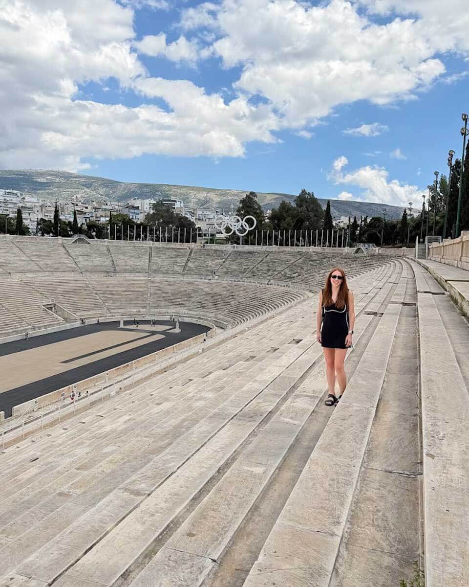 Hannah standing on the track at Panathenaic Stadium in Athens, Greece