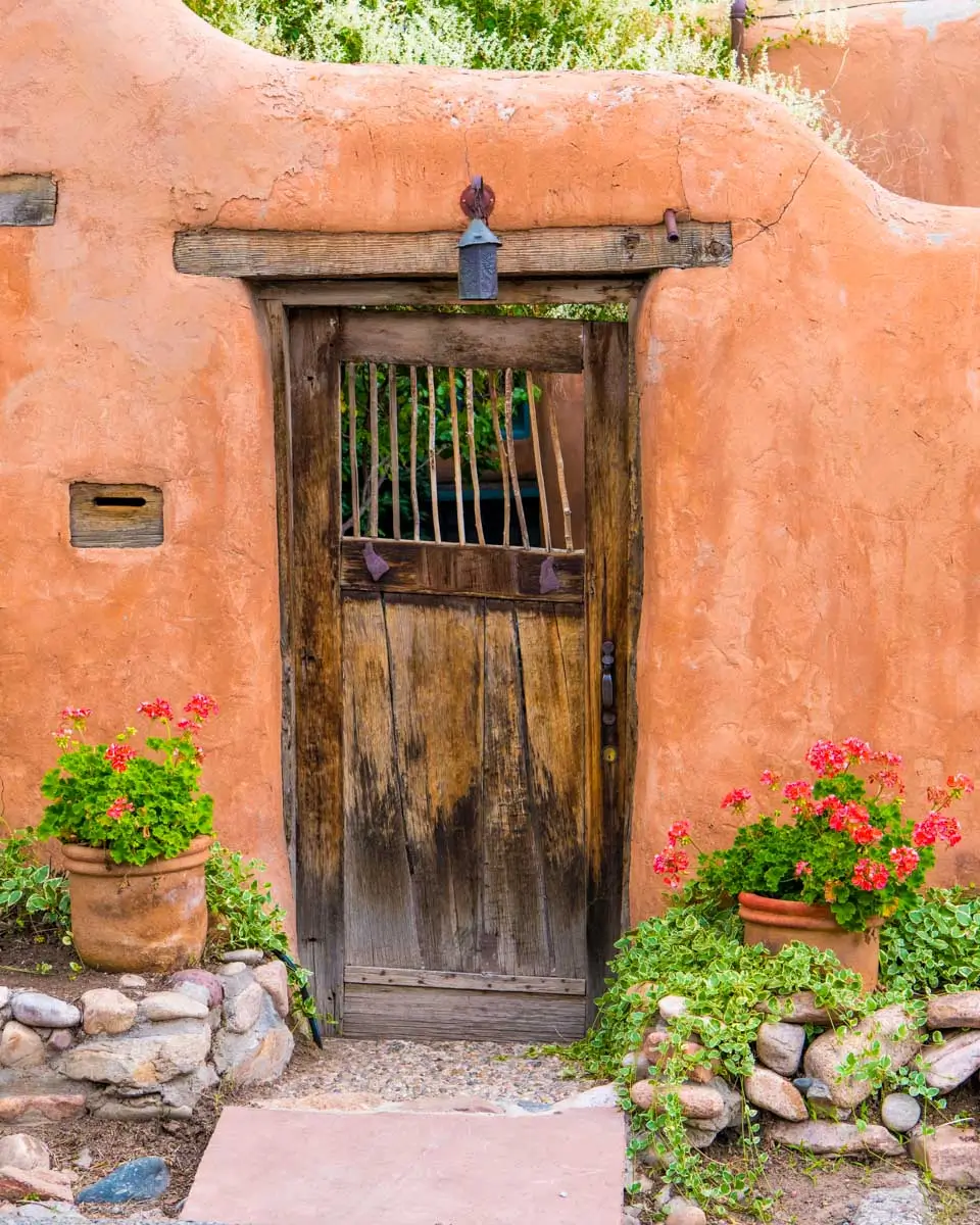 Rustic wood door set in old adobe wall in Santa Fe, New Mexico