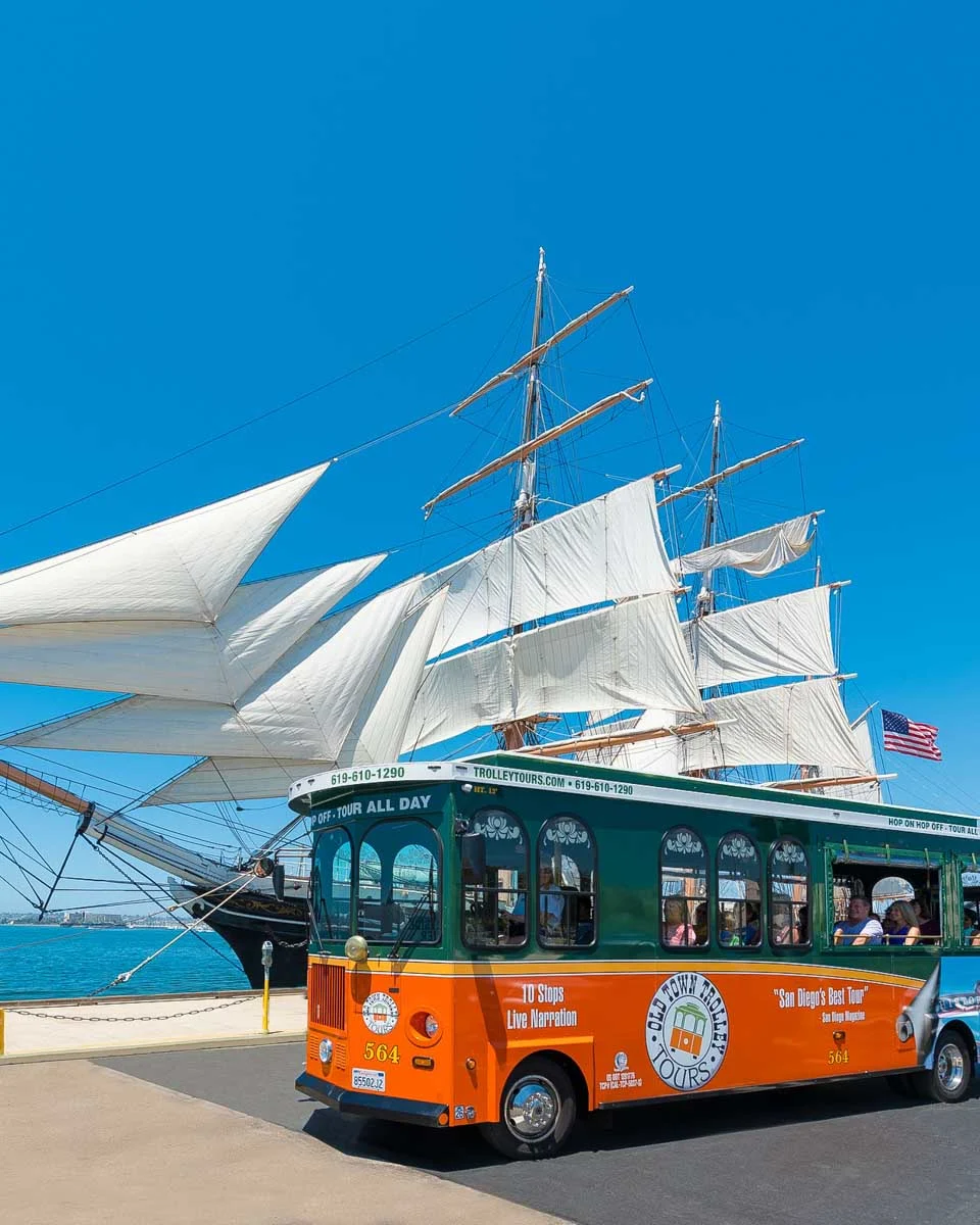 A trolley bus driving along the waterfront in San Diego California