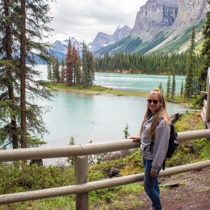 Bailey-poses-for-a-photo-at-Maligne-Lake-looking-over-at-Spirit-Island on a tour from Jasper
