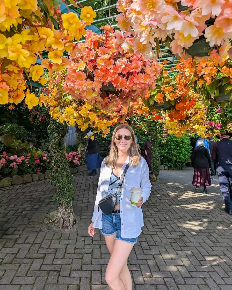 Bailey posing under colorful flowers at The Butchart Gardens in Victoria BC