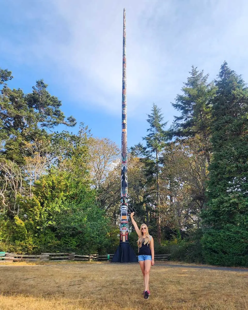Bailey posing with the Beacon Hill Totem Pole in Victoria BC