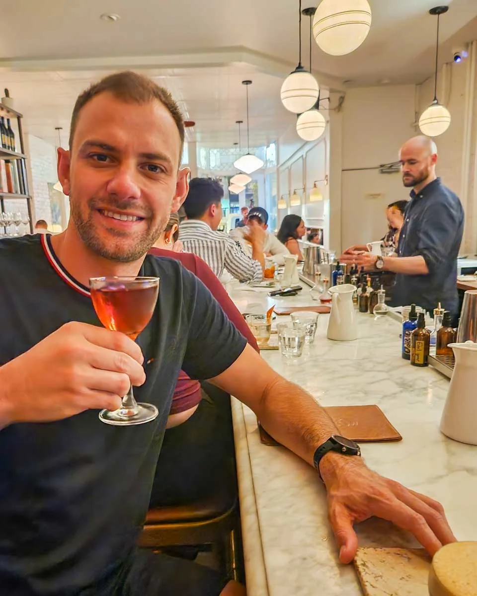 Daniel-drinks-a-cocktail-from-Pompette-Bar-in-Little-Italy Toronto Canada