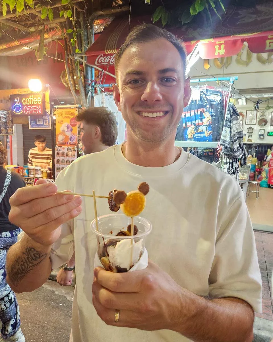 Daniel eats a sweet snack in Chinatown Bangkok Thailand