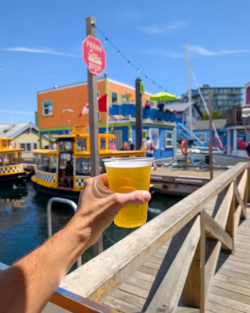 Daniel holding a glass of beer at the Fisherman’s Wharf in Victoria BC