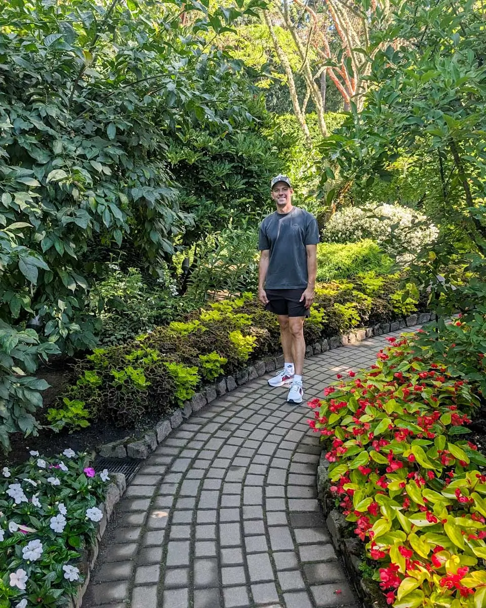 Daniel posing on a pathway in The Butchart Gardens in Victoria BC