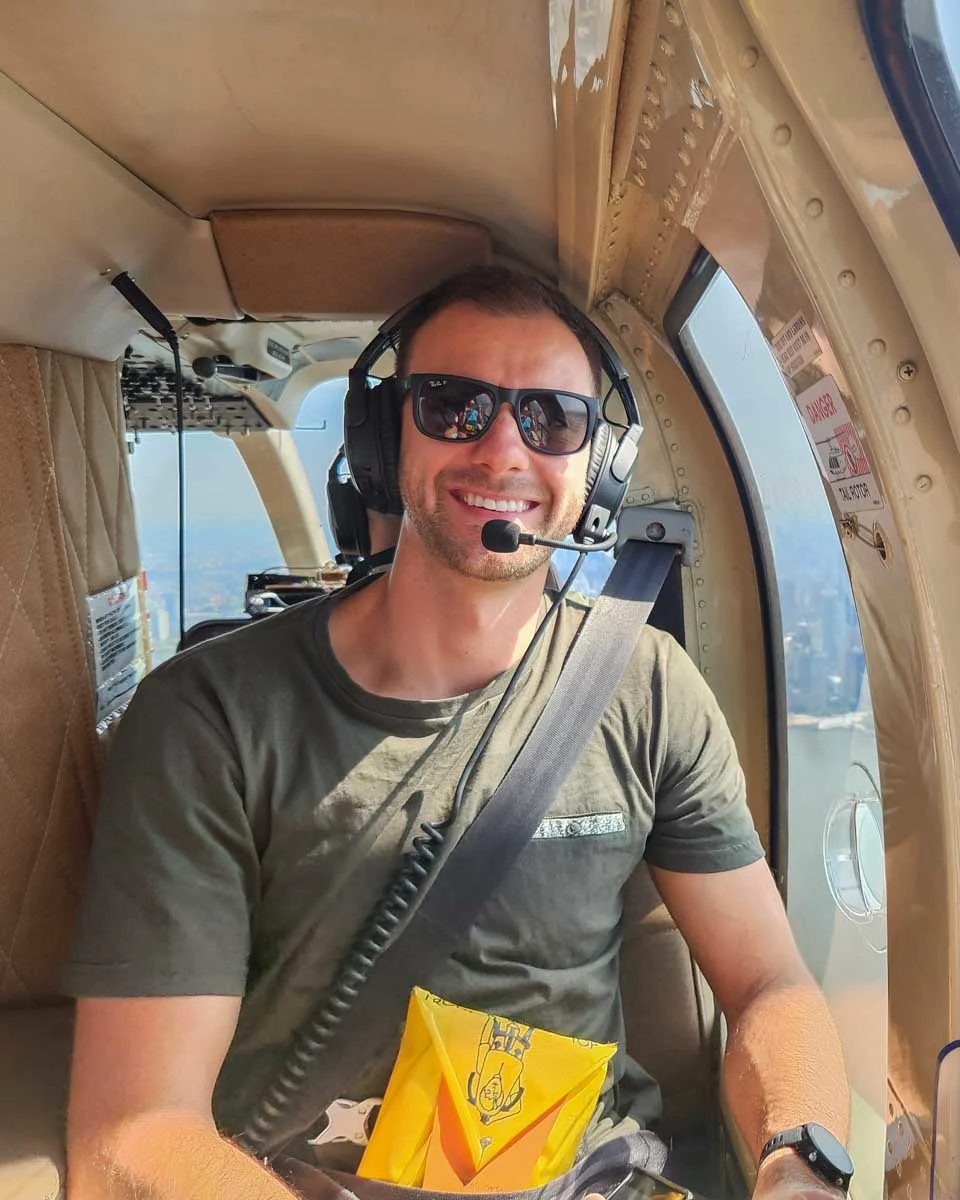 Daniel-smiles-at-the-camera-while-sitting-in-a-helicopter-over Montreal Quebec