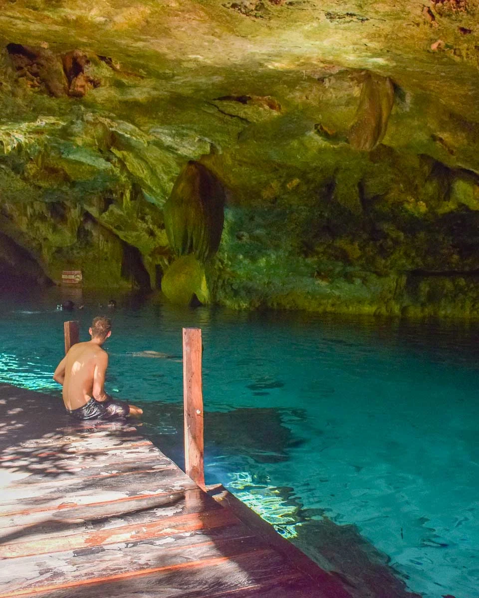 Daniel sits at a cenote on a tour from Tulum Mexico