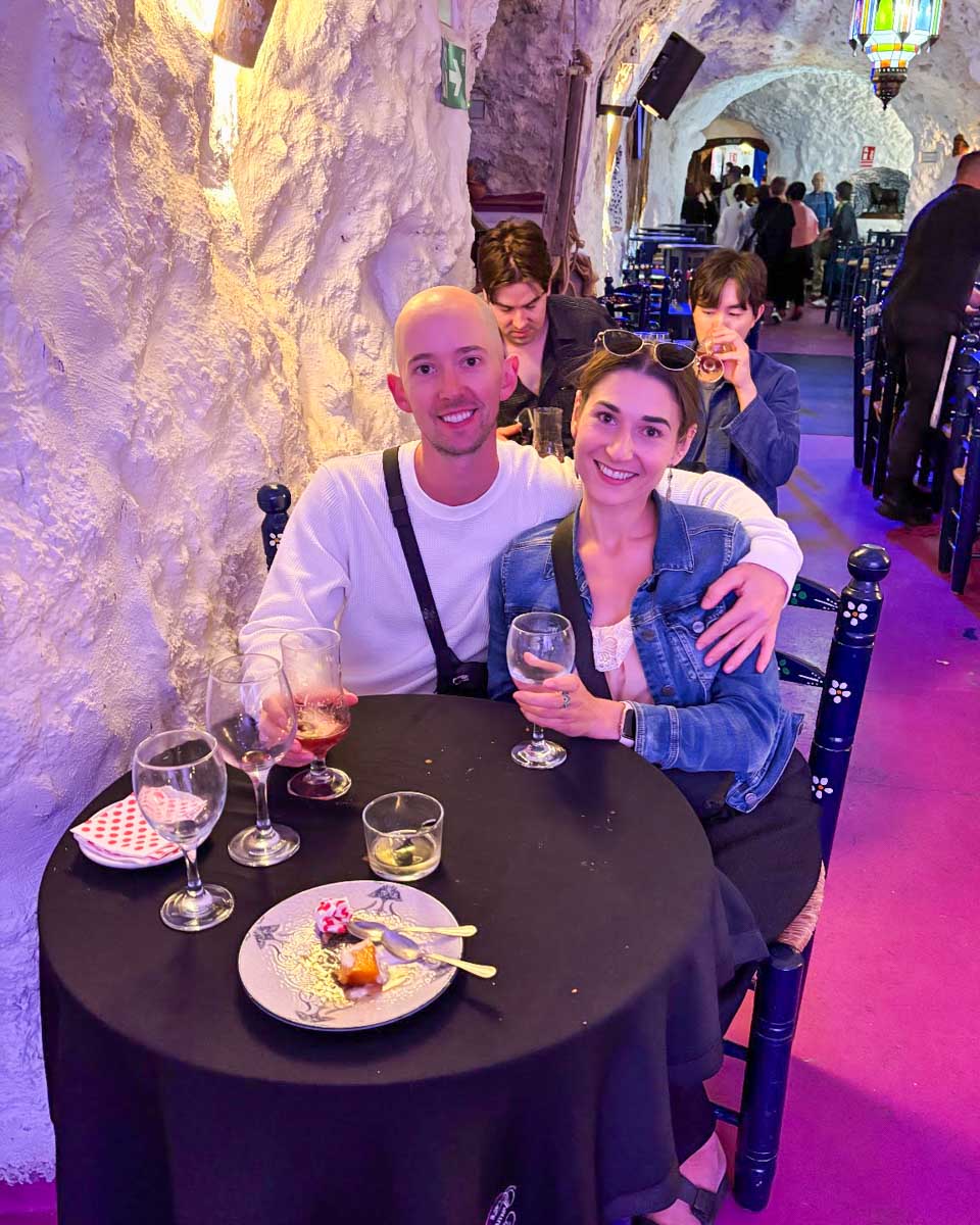 Brittni and Jesse smile at their table watching a flamenco show in Granda, Spain