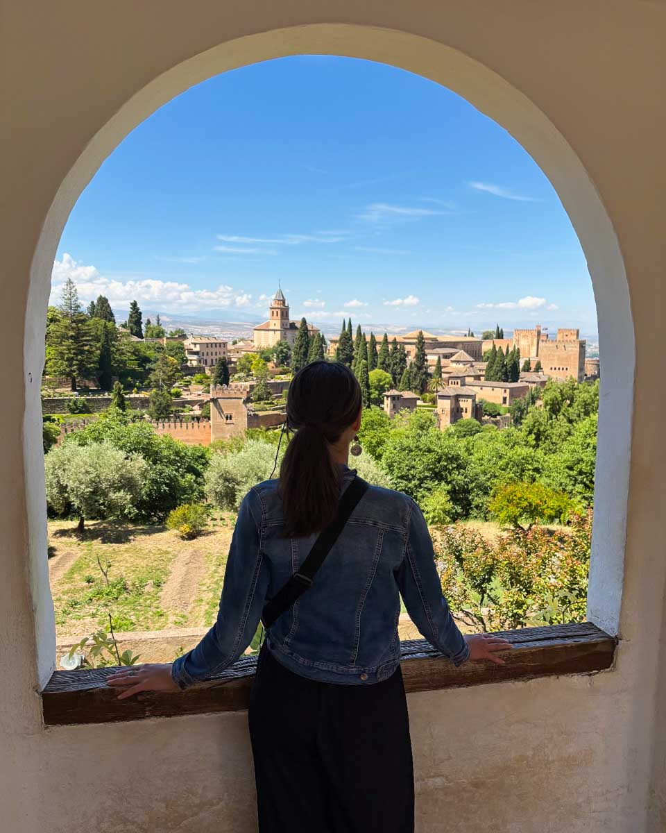 Brittni looks out a window at the Alhambra from the Generalife Gardens in Granada, Spain