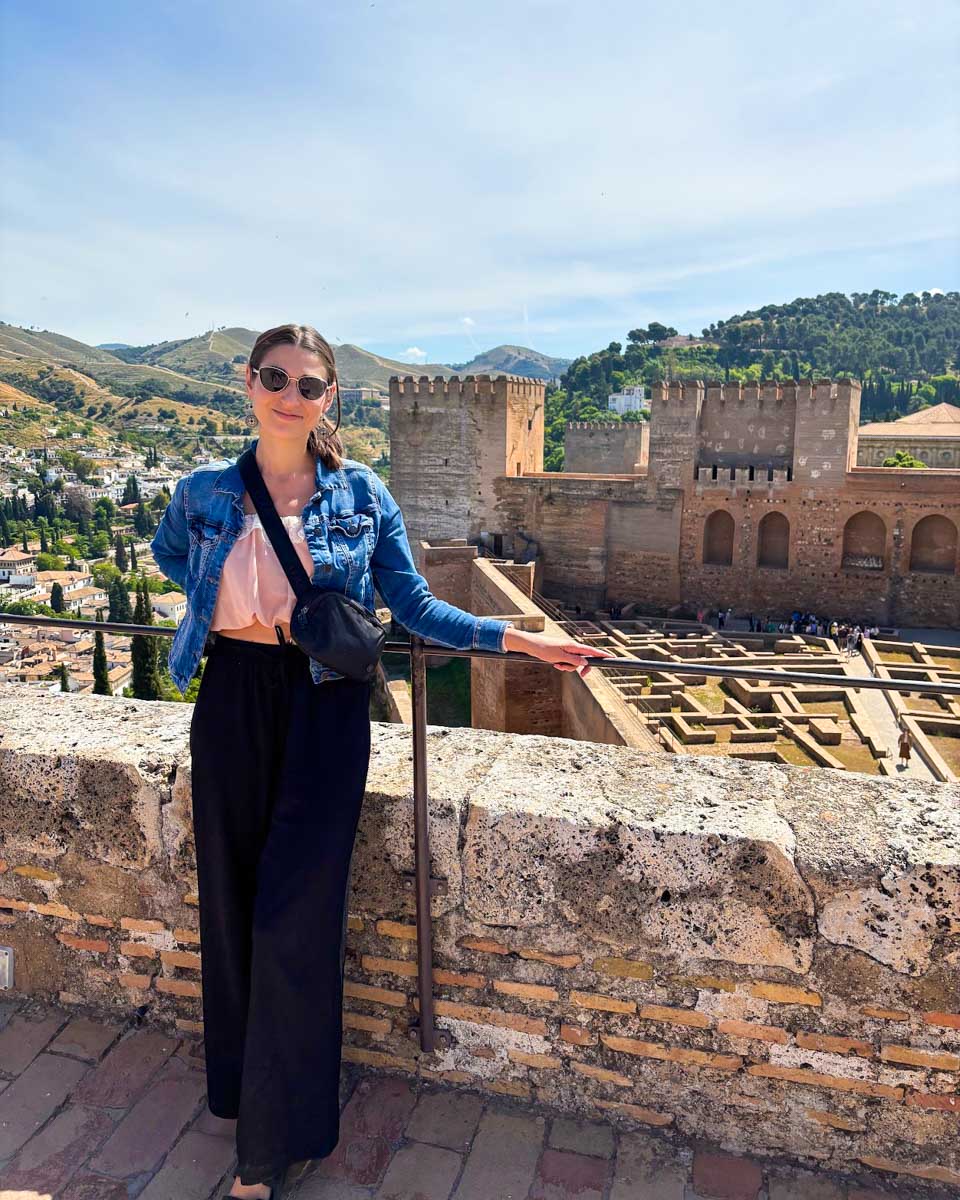 Brittni poses for a photo on one of the fortress towers with the Alhambra in the background on a tour in Granda, Spain