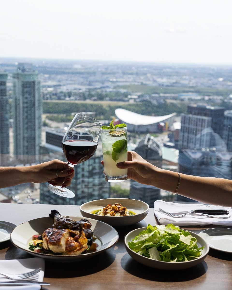 Two people cheers at sky 360 restaurant in calgary