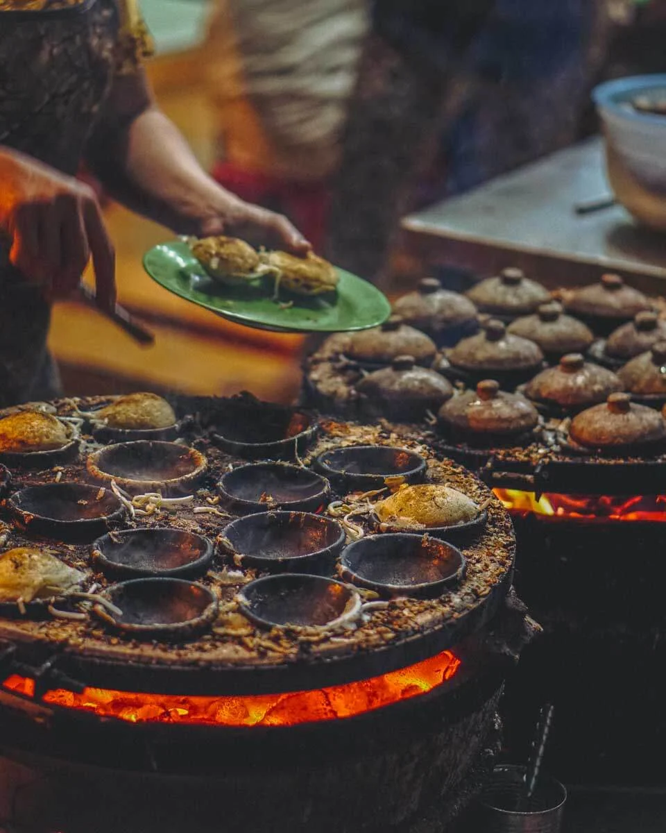 A person in Ho Chi Minh Vietnam makes street food at night
