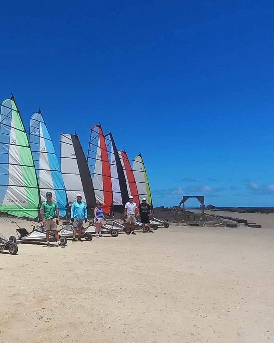 A group of people pose for a picture before landsailing with Bonaire Landsailing Adventures