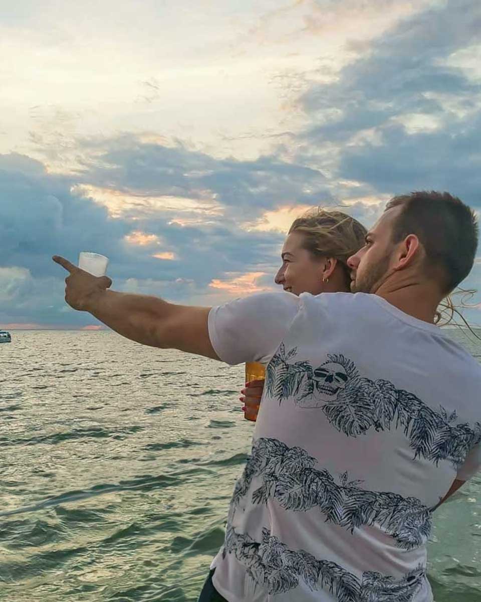 Daniel-points-to-something-while-on-a-sunset-cruise-in-Airlie Australia