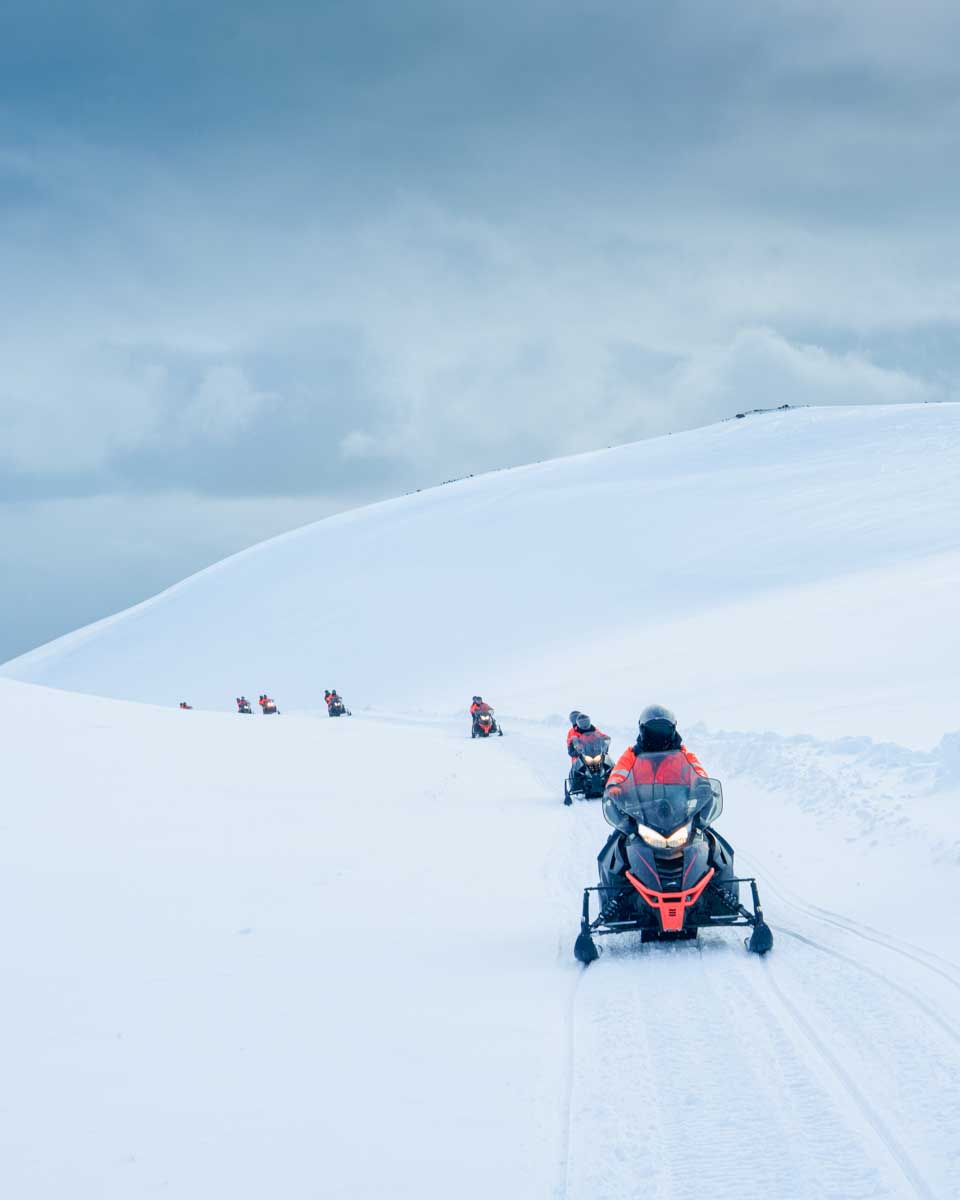 Group of tourist riding snowmobile on a glacier in Iceland