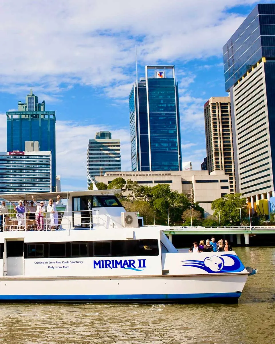 People wave on a river cruise with Koala and River Cruises in Brisbane