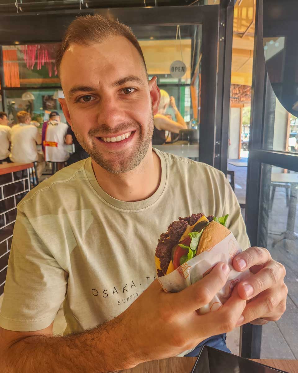 Daniel-enjoys-a-burger-in-Adelaide-Australia
