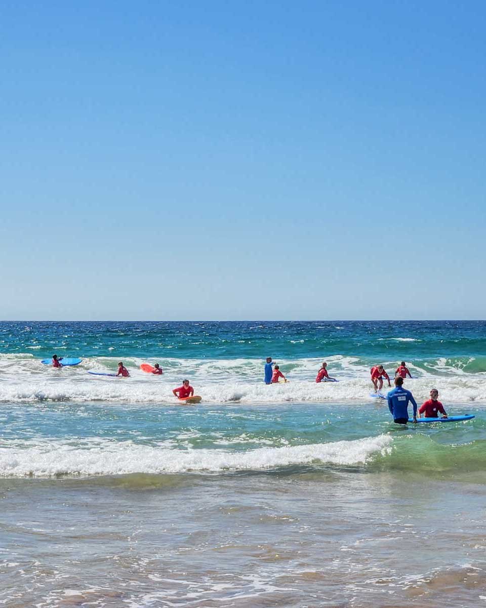 A-group-of-people-learn-to-surf-in-Byron Bay Australia