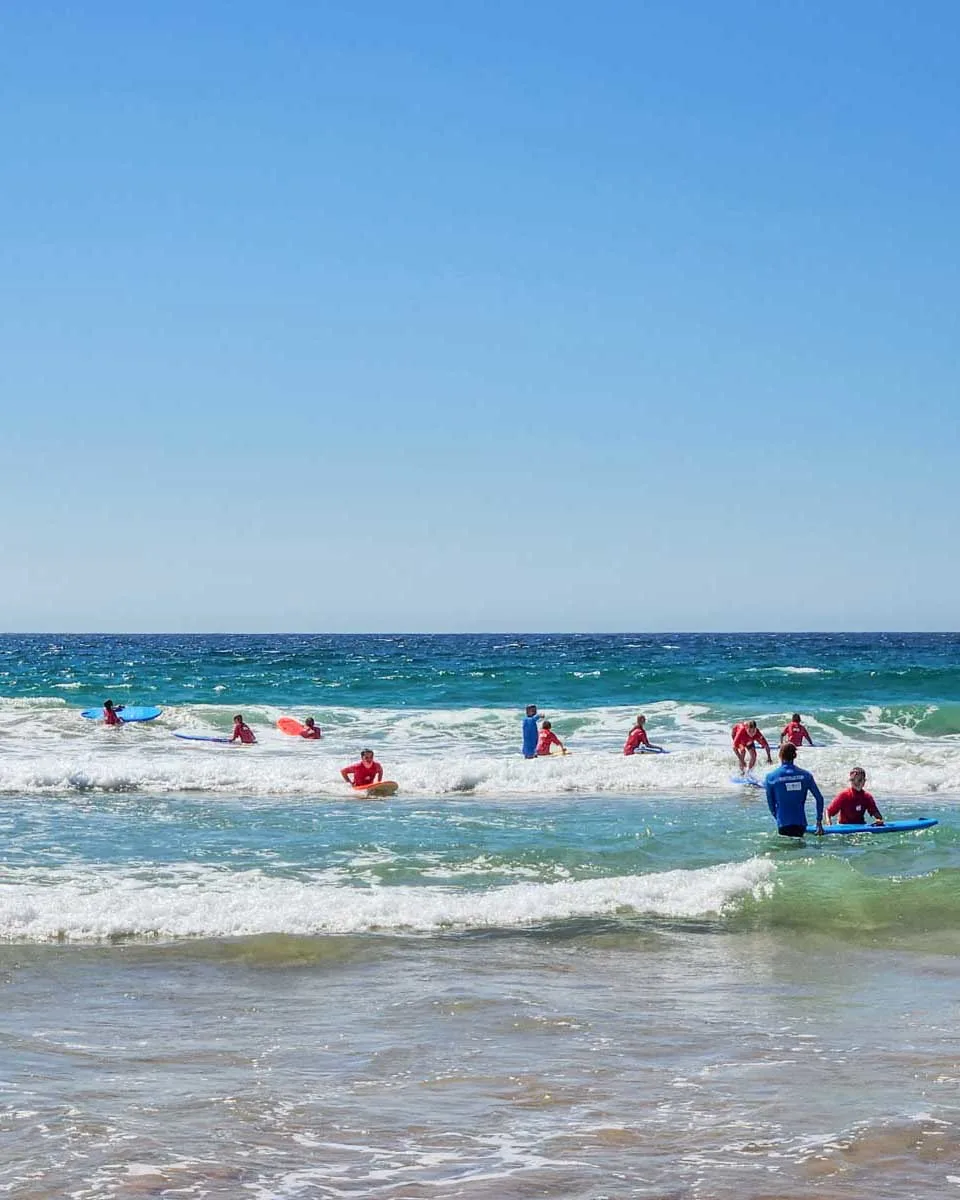 A-group-of-people-learn-to-surf-in-Byron Bay Australia