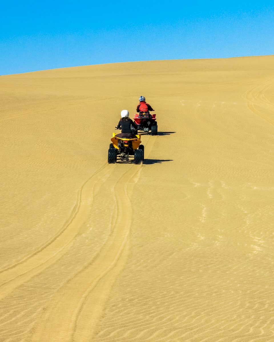 People drive quads in the desert on a tour from Essaouira, Morocco