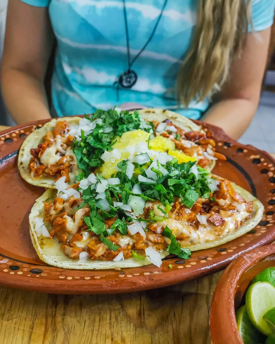 Bailey-sites-behind-a-huge-plate-of-al-pastor-tacos-on-a-taco-tour-in-Sayulita-Mexico