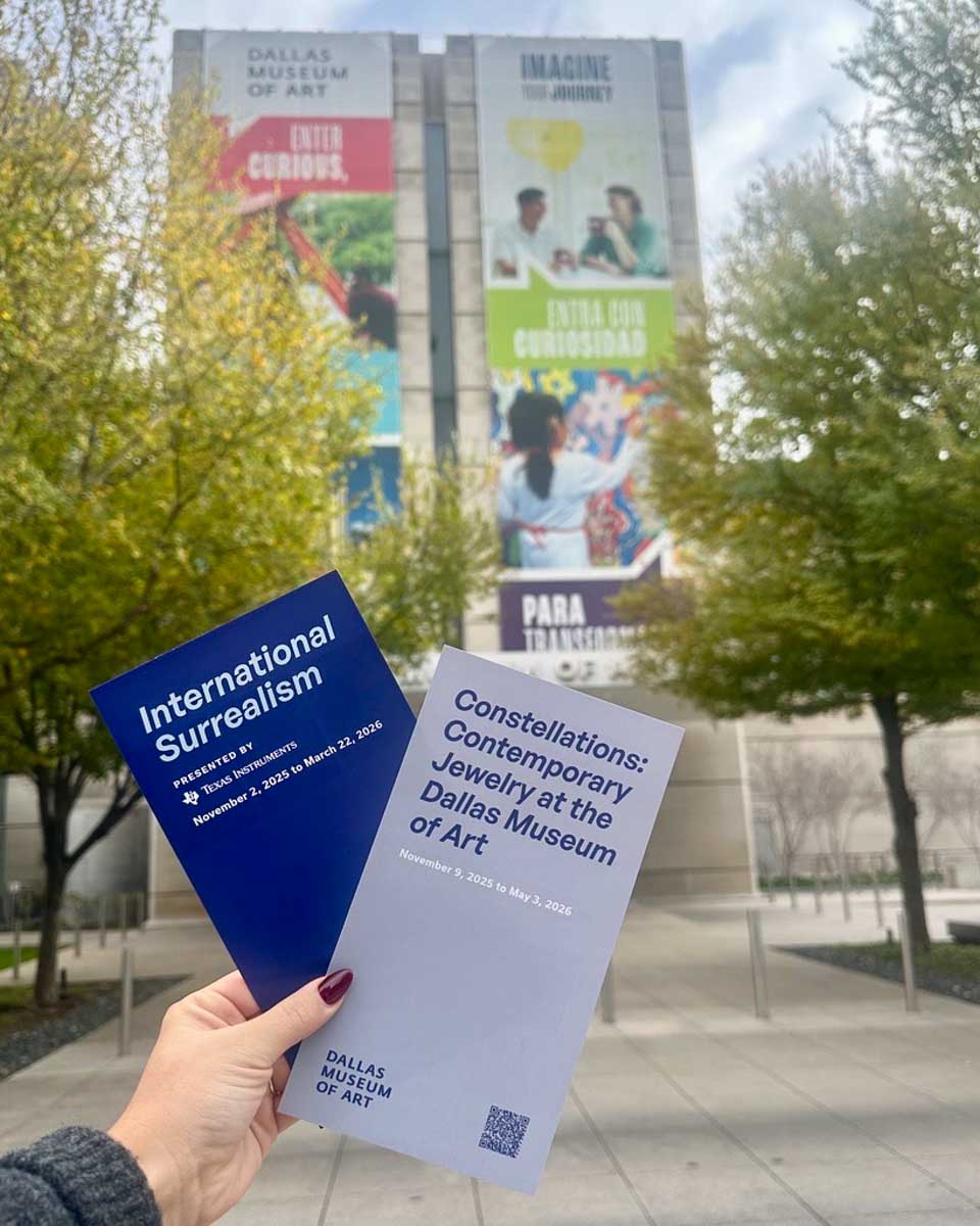 A woman holds pamphlets in front of the Dallas Museum of Art in Dallas