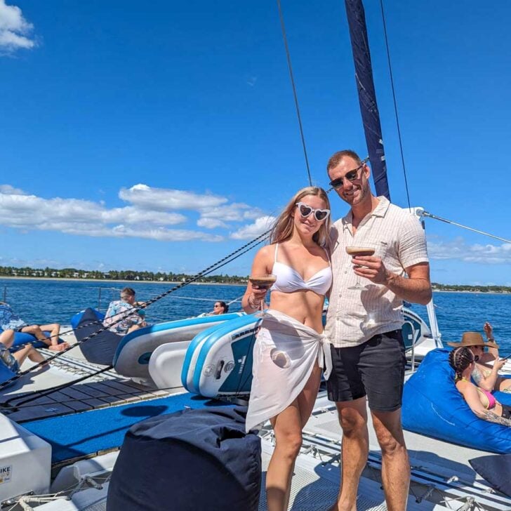 Bailey-and-Daniel-on-the-deck-of-the-sabre-catamaran-holding-drinks-on the way to Ile aux Cerfs Leisure Island, Mauritius