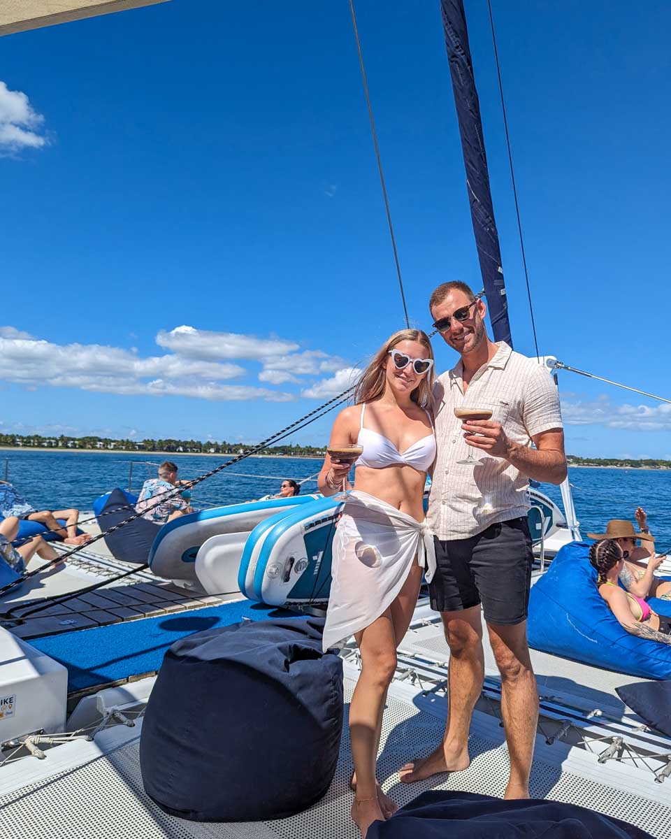 Bailey-and-Daniel-on-the-deck-of-the-sabre-catamaran-holding-drinks-on the way to Ile aux Cerfs Leisure Island, Mauritius