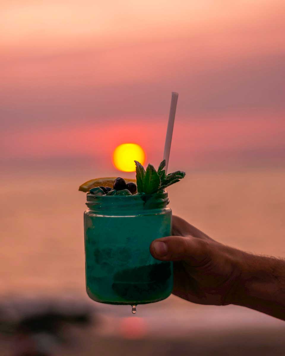 A person holds a cocktail at sunset in Montego Bay Jamaica 1