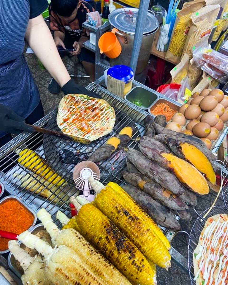 A women prepares food at a street food stall at the Sapa night market